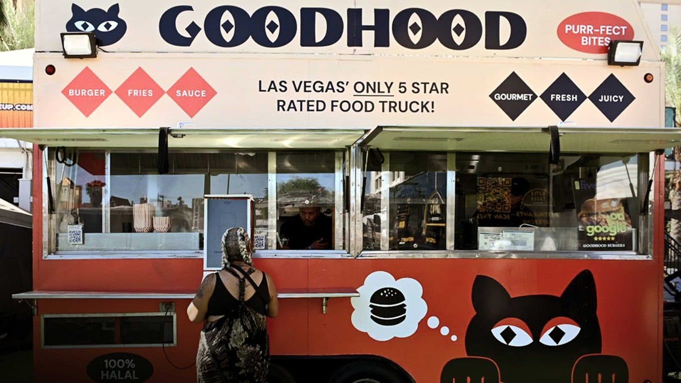 The GoodHood trailer at an event, windows open, with the cat peeking over the side