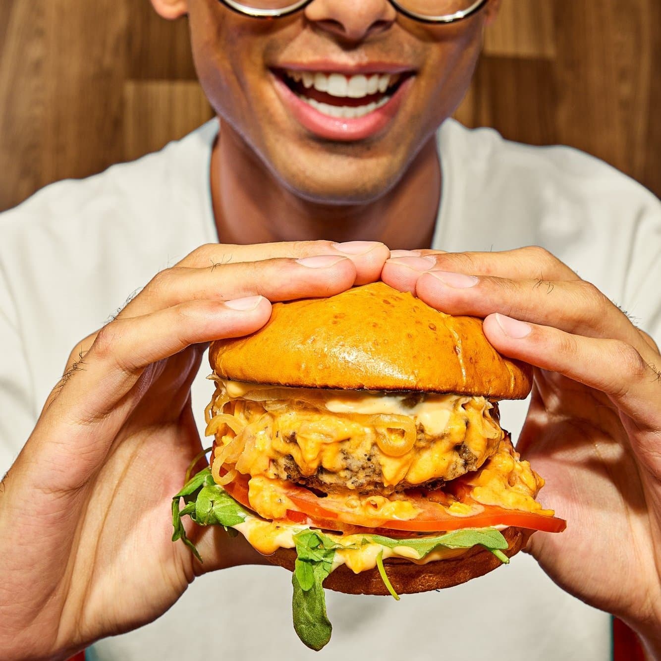 GoodHood lifestyle shot — people eating burgers and fries on the red trays
